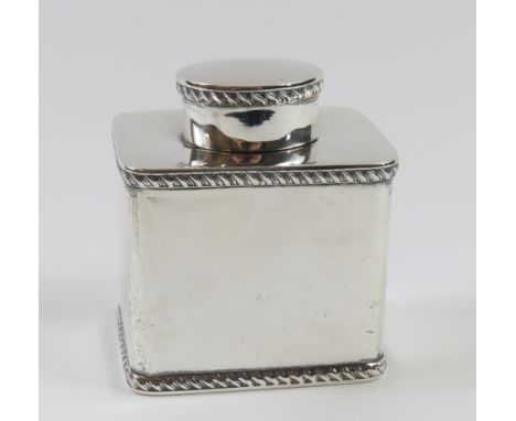 A silver tea caddy with oval lid, made by Asprey and Co. Ltd. in London 1912; with smooth faces and lined at each edge with r