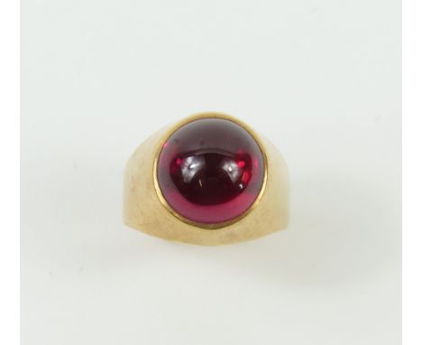 A signet ring set with a round synthetic ruby cabochon, finger size M1/2 (slightly oval band), acid tests as approximately 18