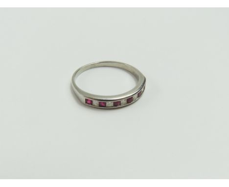 A platinum ruby and diamond half eternity ring, the princess cut diamonds and rubies alternating in a channel setting, finger