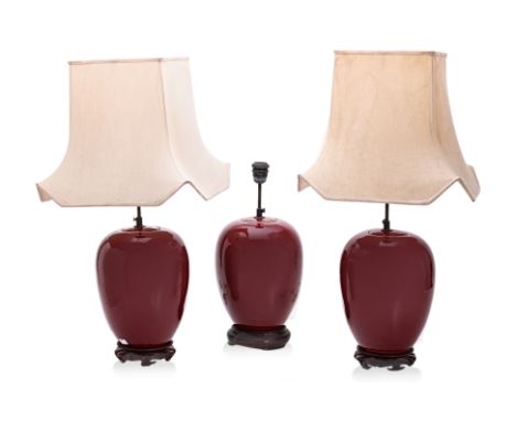 A SET OF THREE SANG DE BOEUF GLAZED TABLE LAMPS
20th C., ovoid form on wood stand, two with square fabric shades (stained); o