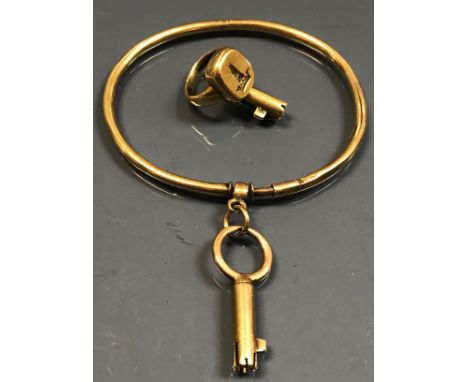 An unmarked yellow metal ring with folding Bramah style key and a yellow metal bangle with a attached Bramah style key, overa