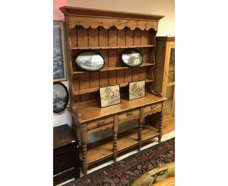 A Victorian pine dresser, the three tier boarded plate rack over three drawers on bobbin turned supports united by a pot shel