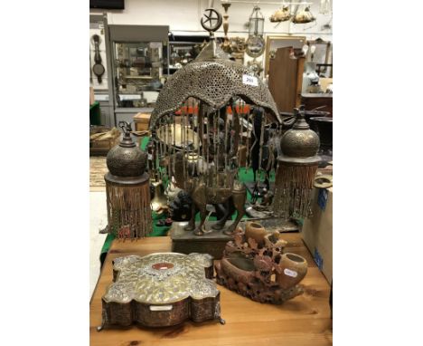 A Middle Eastern brass table lamp in the form of a camel standing on a platform base with Arabic script, together with a Goth