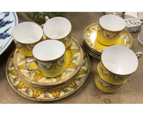 A Royal Worcester part tea set decorated with floral sprays on a yellow ground, comprising cake plate, five tea plates and si