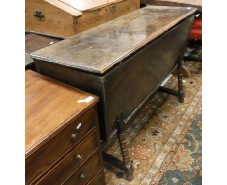 An early 19th Century oak dough bin of typical form, the single plank top with moulded edge over tapered sides over bobbin tu