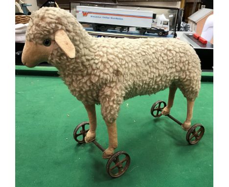 A Steiff wool plush lamb on wheels circa 1920 (button to left ear) CONDITION REPORTS Some discolouration, accretions and some
