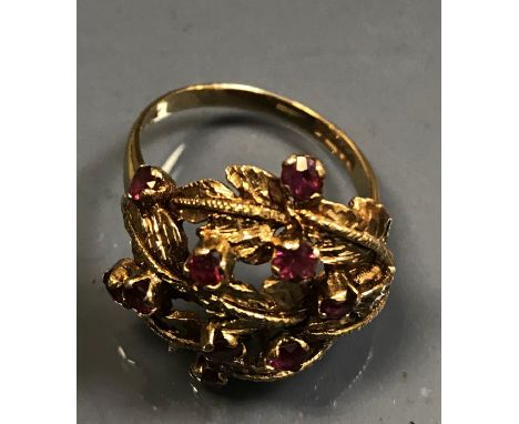 A 9 carat gold leaf spray decorated dress ring set with ten pink garnets, 5.9 g overall, size U