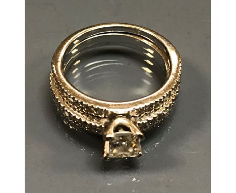 An 18 carat white gold and diamond set two piece ring, the centre 0.5 carat princess cut diamond within three bands of small 