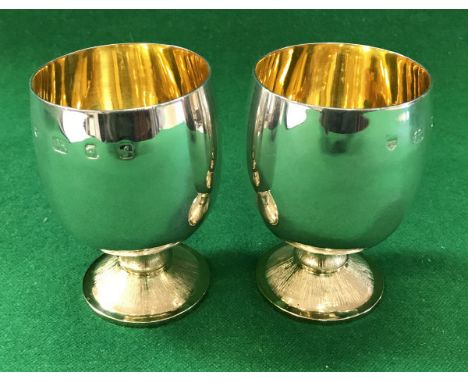 A pair of modern silver goblets with gilt-washed interiors and textured circular feet (by Hugh Alexander Forbes-Latimer, Lond
