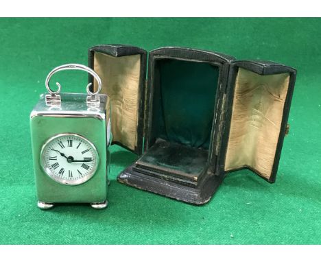 A late Victorian plain silver cased travel clock, the white enamel dial with Roman numerals, raised on squat bun feet, the to