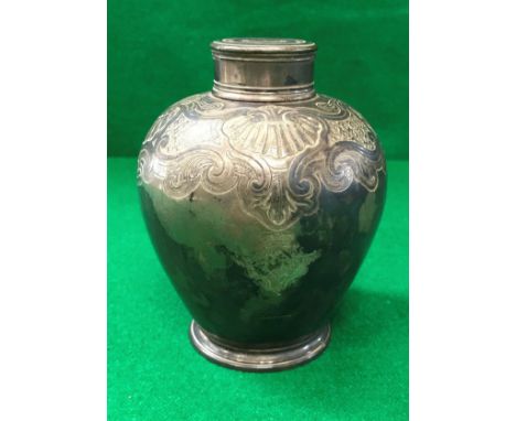 A George II silver tea caddy of Chinese form with scrolling foliate and shell decorated shoulders, raised on a circular foot 