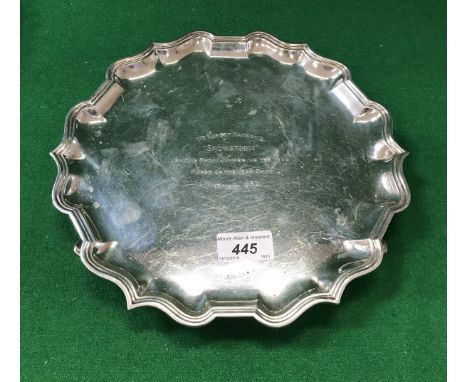 A 20th Century silver salver with pie crust rim, raised on three scroll feet (by C S Harris &amp; Sons Limited, London 1908 f