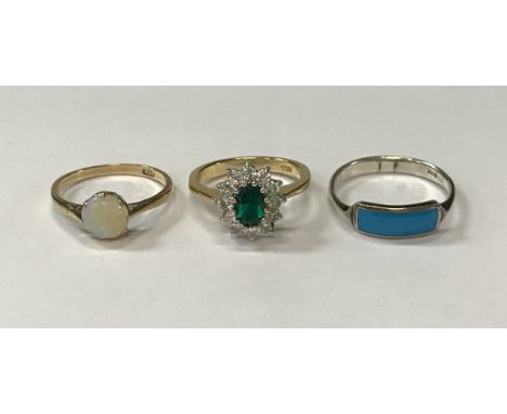 A gold mounted opal ring, silver mounted turquoise ring and a gold mounted emerald and diamond ring