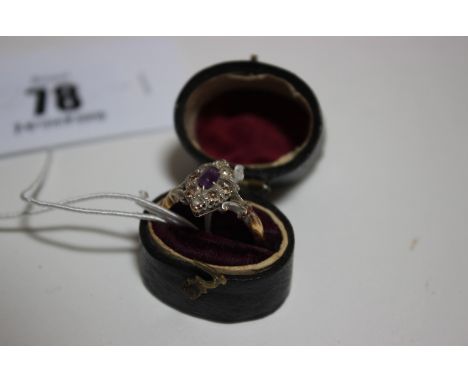 An early 20th Century 18ct gold, amethyst and diamond marquise-shaped cluster ring, centred with a small oval amethyst with a