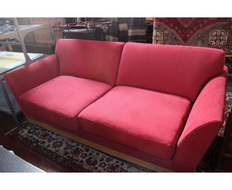 A Benchmark light oak framed sofa, Cerise covered, makers label under frame, number 4561, 200cm wide