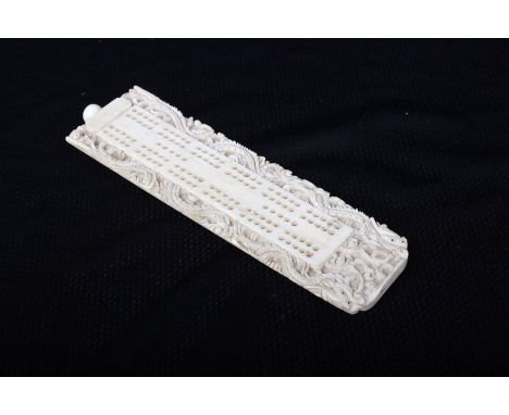 An early 20th century ivory cribbage board, well carved dragon border, 17cm