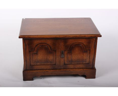 A small oak low cupboard in the 19th century style with bracket feet, 73cm wide, 49cm high