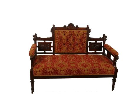 A late Victorian carved walnut two seater sofa, having a button upholstered back and seat, raised on turned legs, 124cm wide