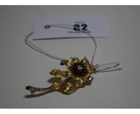 A Continental bi-colour precious metal, ruby and diamond brooch pendant in the form of a flower, the flower-head centred with