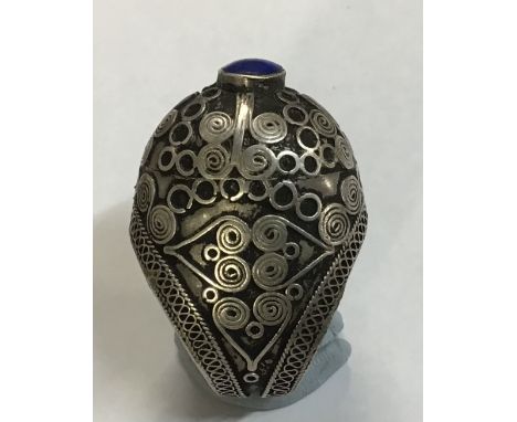 A 16th century Persian/Middle Eastern style ring with scrolling wire work and a polished blue hard stone set in the top. No m