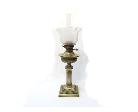 A brass oil lamp, Corinthian column base with clear shade etched with leaves