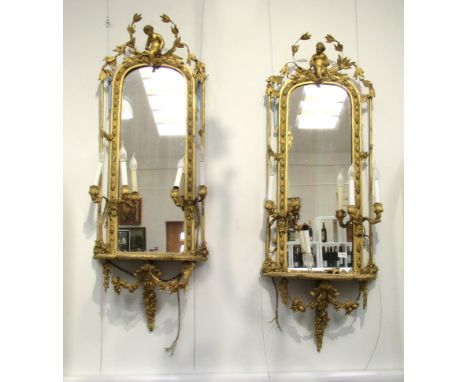 A pair of 19th Century gilt gesso girandole wall mirrors, cherubic crest over two pairs of sconces to a shaped shelf, swag de