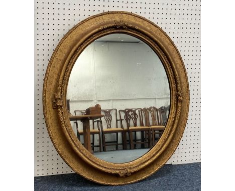 An early 20thC giltwood framed circular Wall Mirror,&nbsp;with moulded foliate decoration, 32in (80cm) x 36in (90cm) 