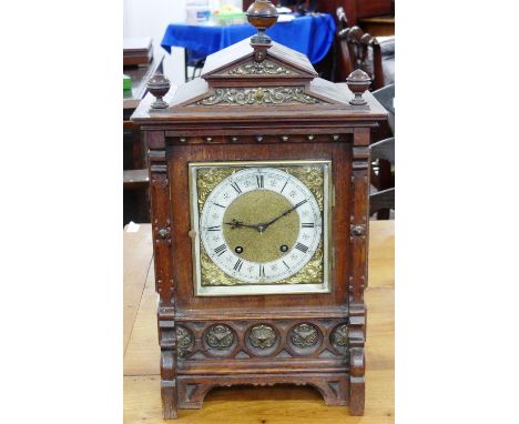A late 19th century striking Bracket Clock, in architectural oak case with brass mounts, the 6in (15cm) square brass dial wit