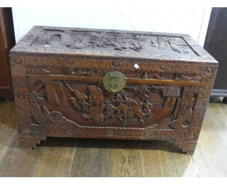 An oriental camphorwood Chest,&nbsp;heavily decorated with battle scenes and foliate border, brass fittings, vacant interior,