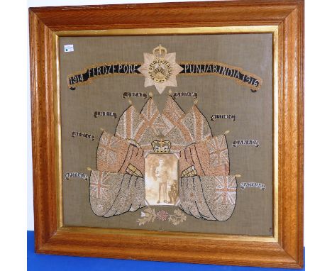 The Devonshire Regiment, a W.W.1 embroidered picture with central photograph of a soldier within flags of empire and inscript