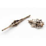 Twee 14 kt. goud met zilveren broches.