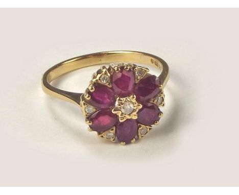 RUBY RING. A 9ct. gold ruby & diamond flowerhead ring. Setting diameter 1.3cm. Size M.