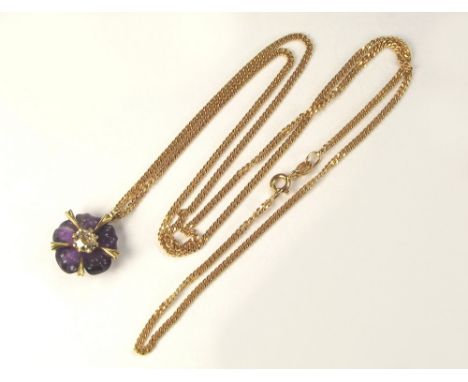 GOLD PENDANT. A carved amethyst & diamond pendant, the central stone of approximately 0.5ct. hung on a long 9ct. gold trace c