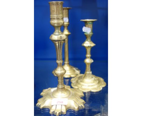 AN 18TH CENTURY BRASS PETAL CANDLESTICK, 24cm high and two similar (3) 