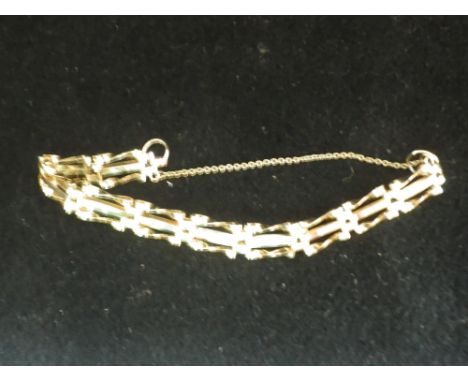 AN UNMARKED YELLOW METAL GATE LINK BRACELET with safety chain, 7.5gm 