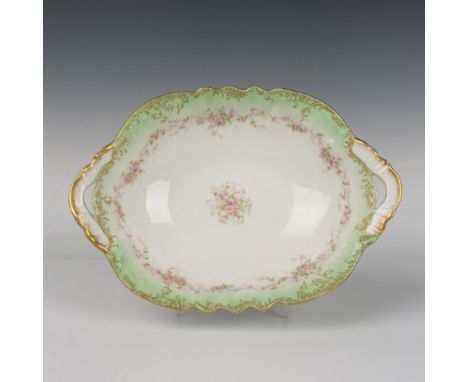 A beautiful vegetable serving bowl with two handles and a gilt scalloped edge. Decorated in a light clover-green edge with a 