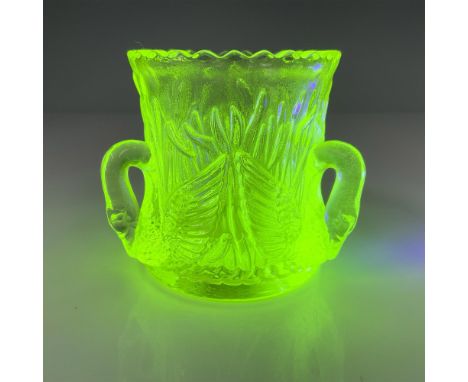 Vase-shaped holder in pressed yellow uranium glass with three decorative swan handles and cattail motif on the exterior. Fluo