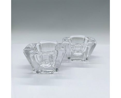 A set of 2 clear votive candle holders in four petal shape. Orrefors marked. Artist: Anna EhrnerIssued: 20th centuryDimension