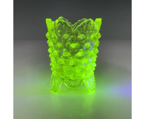 Vase-shaped toothpick holder in yellow uranium glass with three decorative feet and dot pattern to the exterior. Fluoresces u