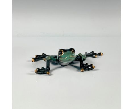 A glossy hand crafted figure using modern firing techniques of a frog with a black and sage green body and gold-colored detai