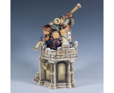 A figure of a snowy castle tower with five children at the top while three of them are playing horns. Signed Christina Goihl.