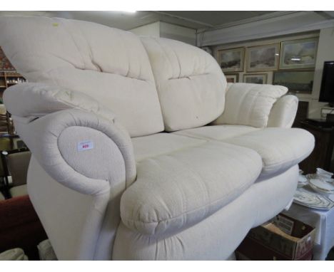 CREAM UPHOLSTERED TWO-SEATER SOFA.