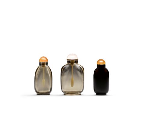 Three rock crystal snuff bottlesIncluding two well-hollowed smoky rock crystal bottles: the first a rounded rectangular bottl