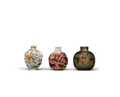 Three snuff bottlesThe first a molded and enameled porcelain bottle decorated with a continuous scene, possibly depicting the
