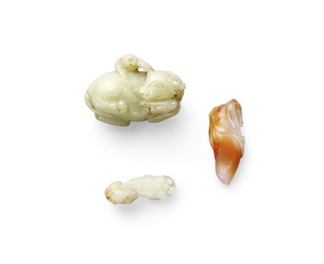 Two jade carvings and a carnelian toggleThe largest a pale green jade pebble carved as a young boy climbing onto a recumbent 
