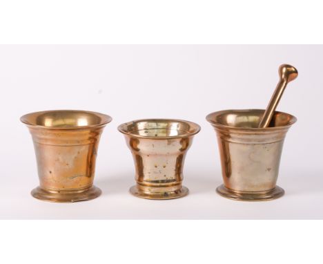 A GROUP OF THREE POLISHED BRONZE MORTARS (4)19th CenturyTogether with a pestle, the taller - 12.5cm diameter; 10cm high