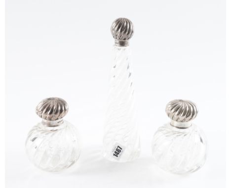 A SILVER TOPPED SCENT BOTTLE TOGETHER WITH A PAIR OF SILVER TOPPED SCENT BOTTLES (3)The first Victorian scent bottle of taper