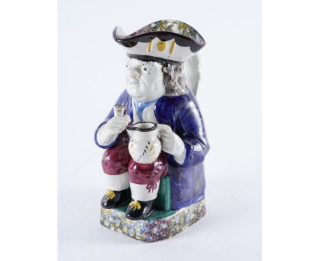 AN `ORDINARY' POTTERY TOBY JUGProbably Yorkshire or Portobello, circa 1830Modelled seated holding a glass and jug, wearing a 