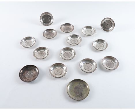 FIFTEEN CIRCULAR DISHES MOUNTED WITH COINS (15)The coins mostly Chinese, but including a Mexican eight reales, combined gross