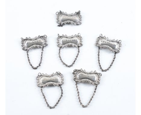 A SET OF SIX VICTORIAN SILVER DECANTER LABELS (6)Each of shaped rectangular form, having a floral, foliate and scroll decorat